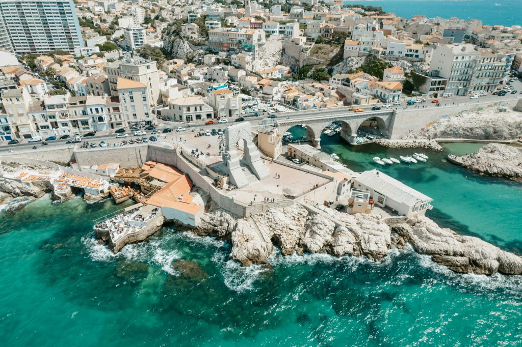 Vue aérienne de la Corniche Kennedy et de l'Anse des Catalans à Marseille, mer turquoise et rochers calcaires © Martin Baron / Unsplash